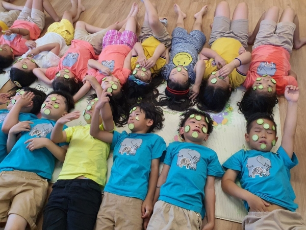 꿈의유치원 아이들이 얼굴이 오이를 붙이고 있다.